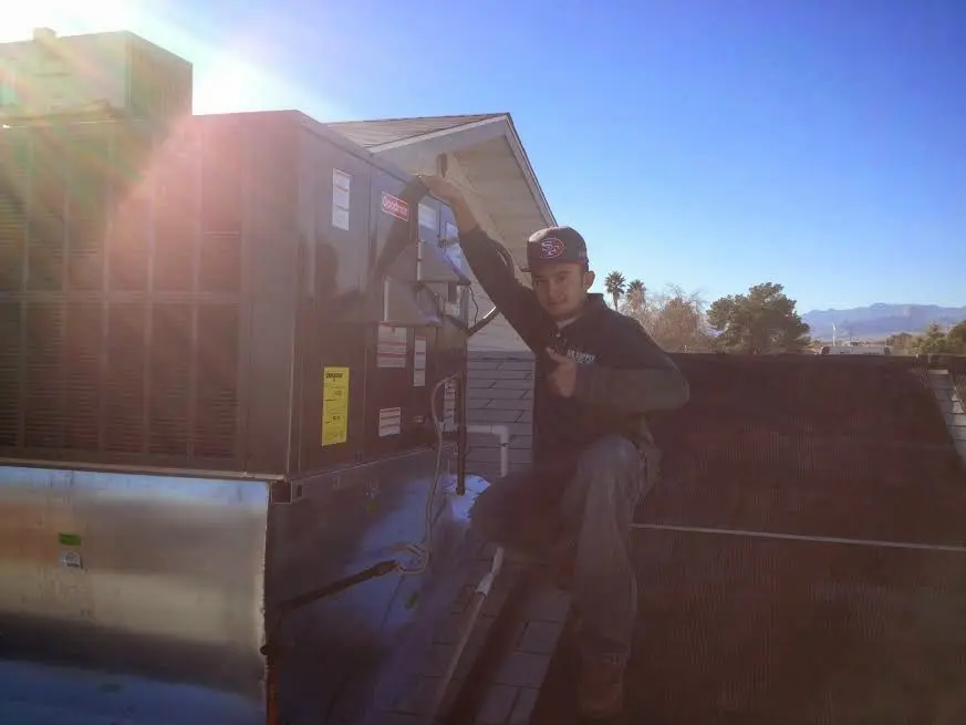 HVAC technician performing AC Tune-Up on a rooftop unit in Hammond