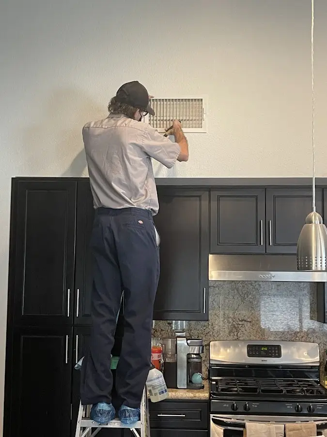 Technician inspecting an air vent during HVAC service in Hammond